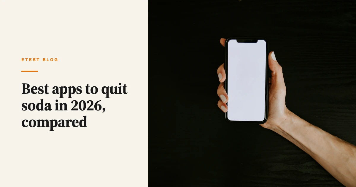 A hand holding a phone with a blank white screen over a dark wooden desk