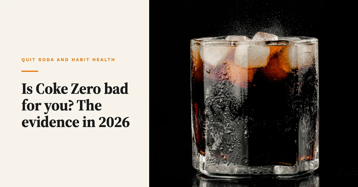 A glass of dark cola with ice cubes and fizz on a black background